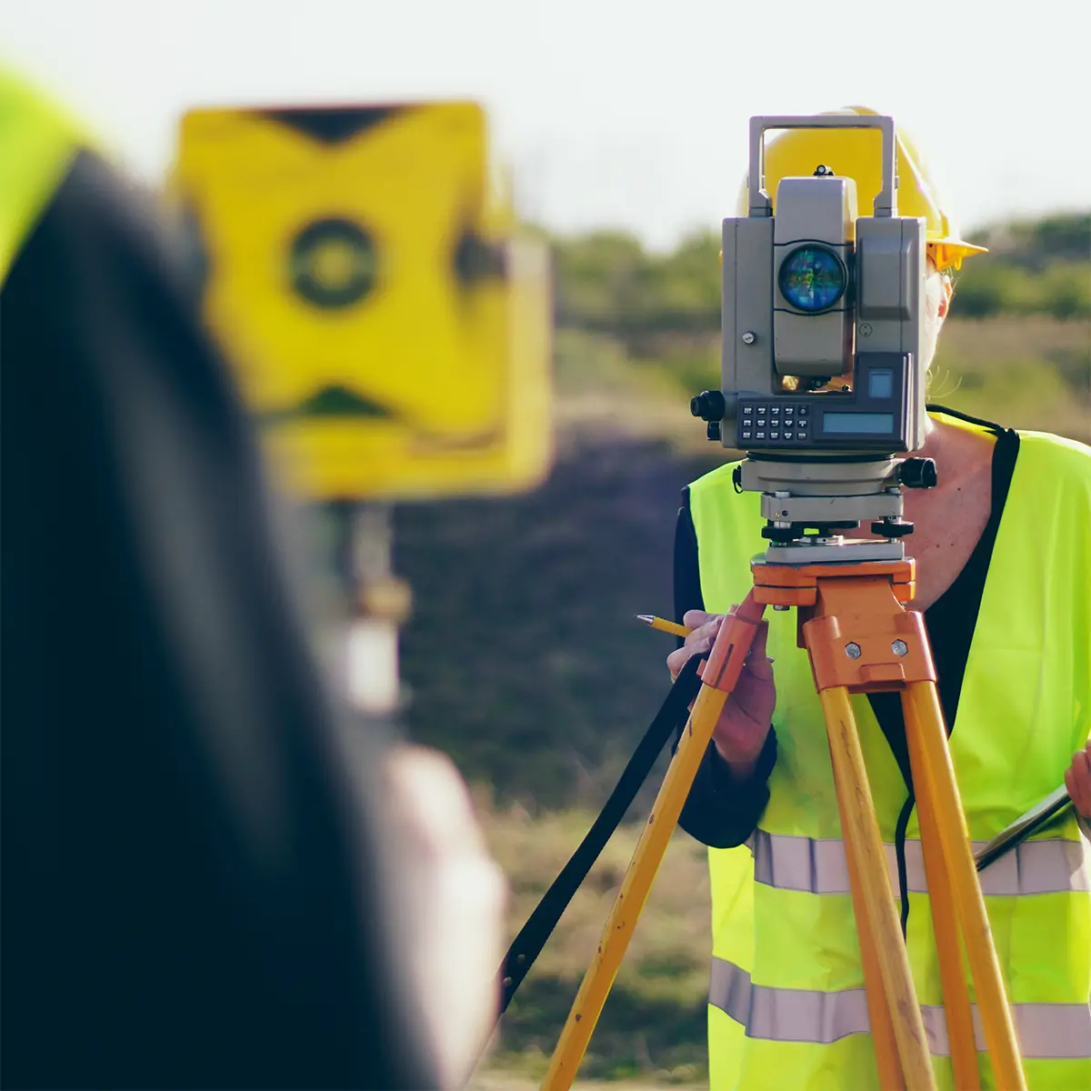 A professional land surveyor using a total station for precise measurements in the field. Prime Edge Technical Services LLC provides expert land surveying solutions for construction, mapping, and infrastructure projects.